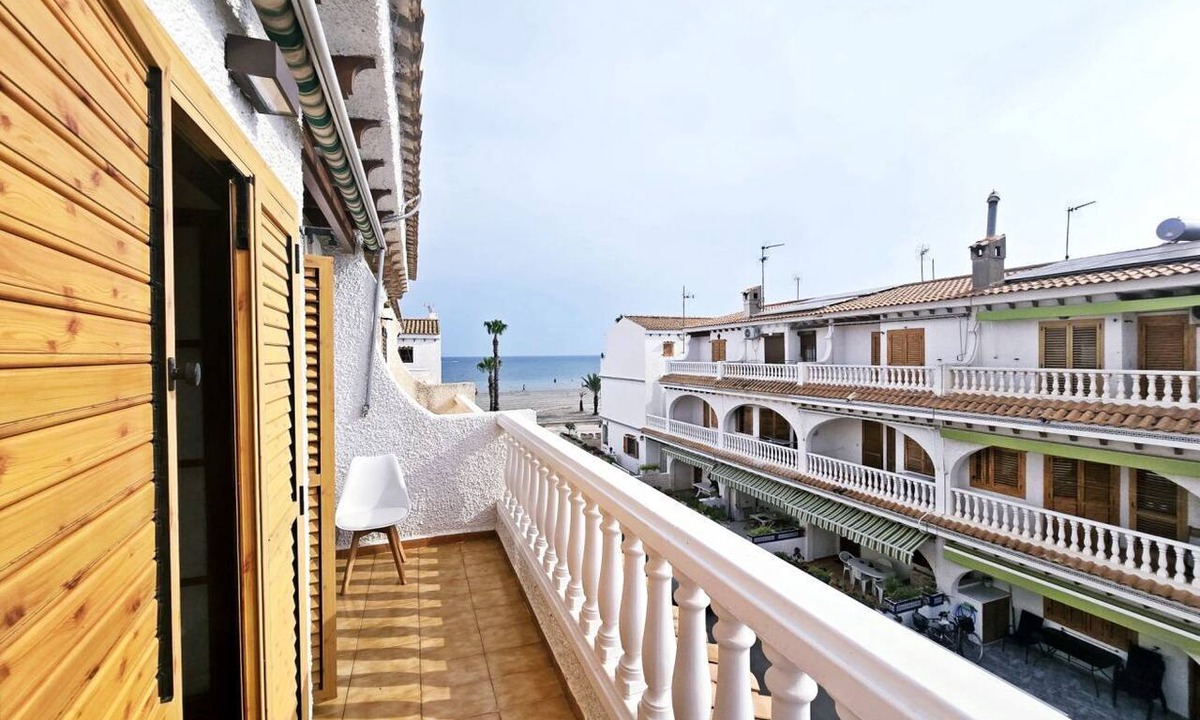 Santa Pola Villa | Bright duplex near the beach in Santa Pola – Terrace with side sea viewsCozy duplex apartment for 6 people, located in a quiet residential area, just a few steps from the beach.On the ground floor, you'll find a living room decorated with a mural simul